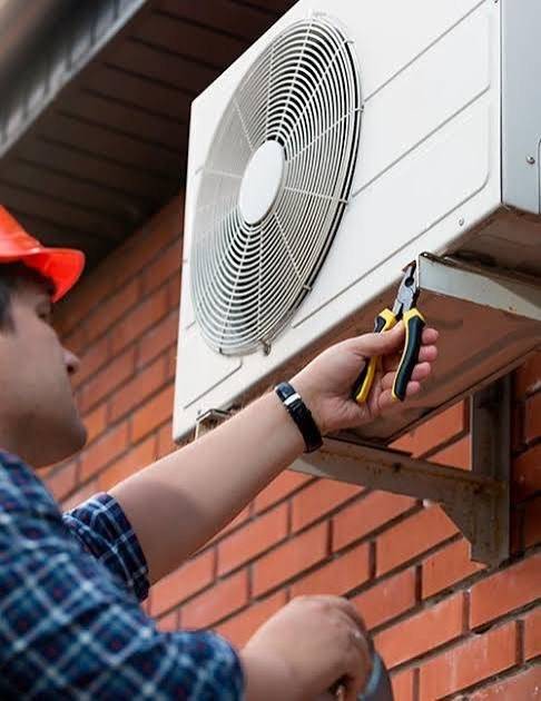 Técnico revisando la unidad exterior de un aire acondicionado