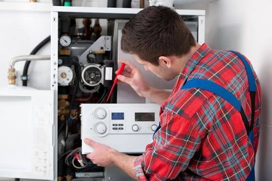 Técnico ajustando el panel de control de una caldera de condensación