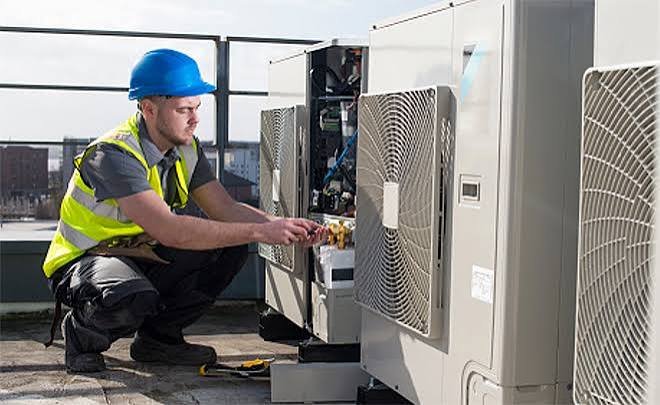 Técnico revisando una unidad exterior de aire acondicionado