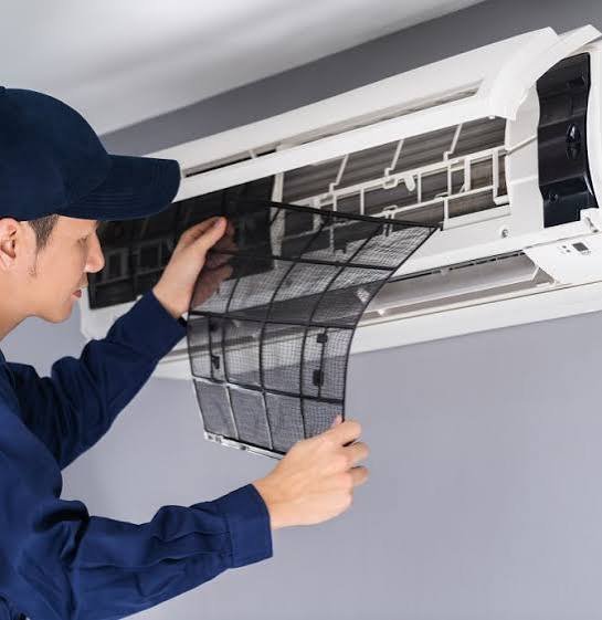 Técnico limpiando la batería de un split de aire acondicionado