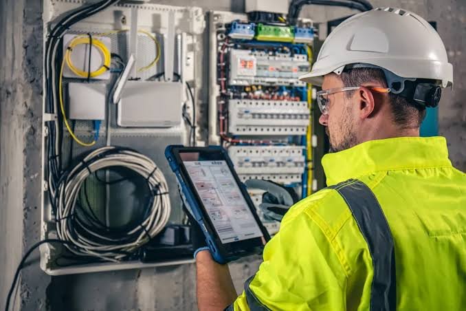 Electricista en Barcelona revisando un cuadro eléctrico con una tableta