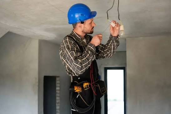 Electricista con casco trabajando en una instalación