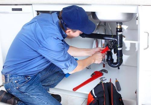 Fontanero reparando el desagüe de un fregadero