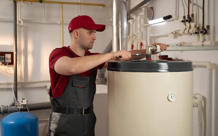 Técnico de calderas trabajando en el interior de un equipo de calefacción