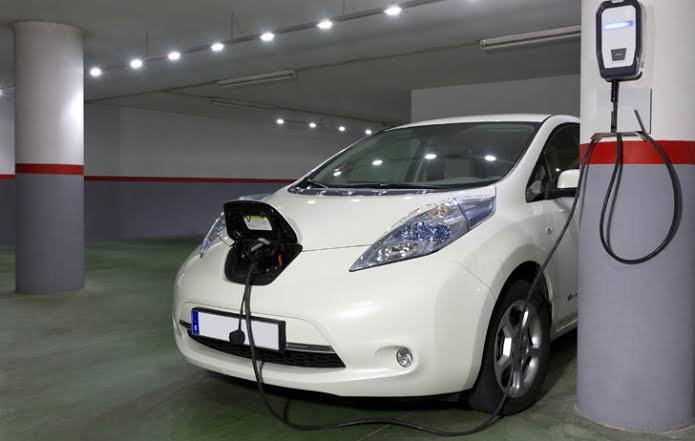 Coche eléctrico cargando en un punto de recarga de garaje