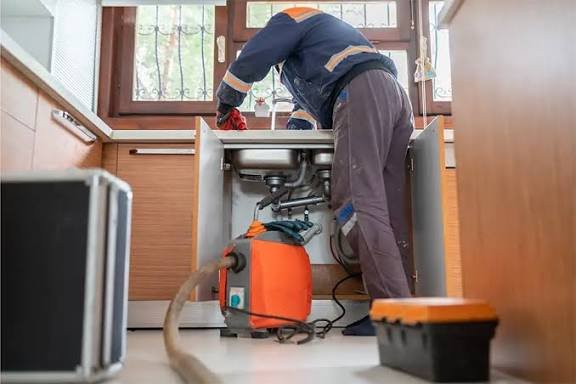 Fontanero desatascando un desagüe con máquina