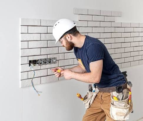 Electricista instalando mecanismos en una pared