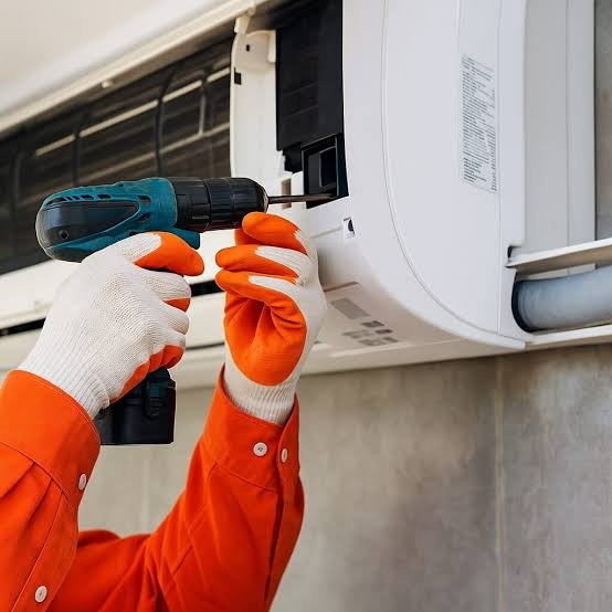 Técnico trabajando en una unidad exterior de aire acondicionado