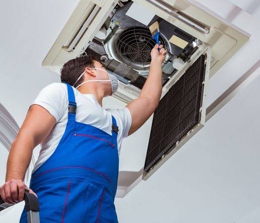Técnico limpiando la unidad interior de un aire acondicionado